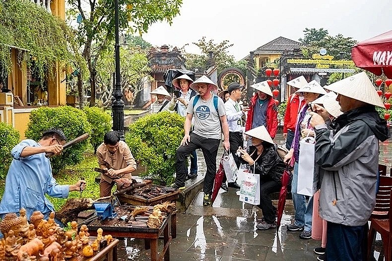 International tourists learn about the production process of handicraft products in Hoi A City on January 1. (Photo: Tan Nguyen) International tourists learn about the production process of handicraft products in Hoi A City on January 1. (Photo: Tan Nguyen)