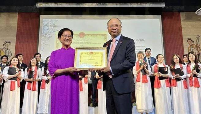 Vietnamese Ambassador Dinh Toan Thang (R) presents the ambassador’s Certificate of merit to the choir in recognition of its contributions. Photo: VNA Vietnamese Ambassador Dinh Toan Thang (R) presents the ambassador’s Certificate of merit to the choir in recognition of its contributions. Photo: VNA