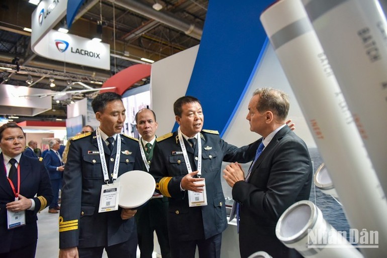 Members of the Vietnamese delegation listen to an expert from the Thales group introducing new naval weapons and technologies at Euronaval 2024. (Photo: VNA)