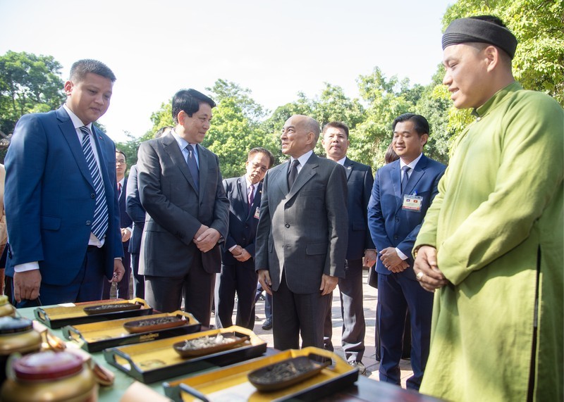 President Luong Cuong and Cambodian King Norodom Sihamoni listen to an introduction to Vietnam's precious teas. (Photo: Nhan Dan)