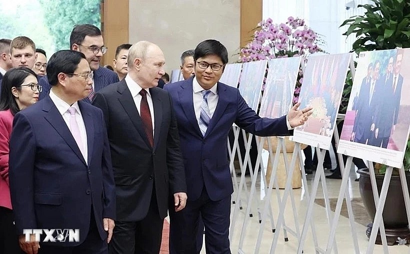Prime Minister Pham Minh Chinh (L) and Russian President Vladimir Putin (C) visit a photo exhibition showcasing cooperation between the two countries. (Photo: VNA) Prime Minister Pham Minh Chinh (L) and Russian President Vladimir Putin (C) visit a photo exhibition showcasing cooperation between the two countries. (Photo: VNA)