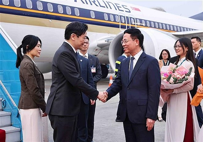 Minister of Science and Technology Nguyen Manh Hung (R) welcomes Singaporean Prime Minister Lawrence Wong and his spouse at Noi Bai International Airport , Hanoi. (Photo: VNA)