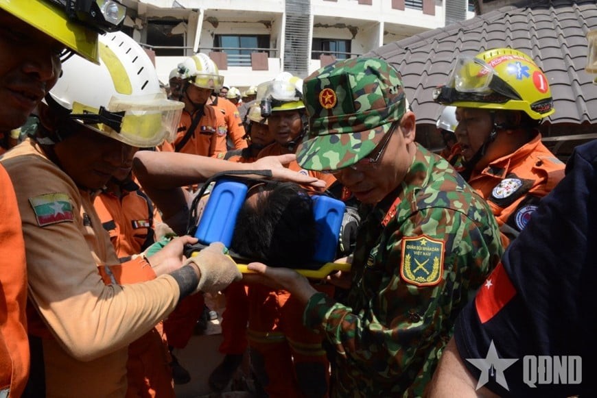Rescue teams from Vietnam, Myanmar, and Turkey bring victim Htet Maung Maung to the ambulance. (Photo: People's Army Newspaper)