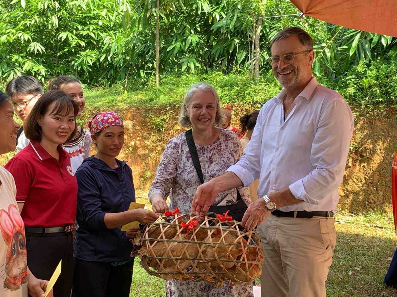 Florence Cavalier (second from right) and Olivier Brochet, French Ambassador to Vietnam (far right), present hens and sows to disadvantaged households in Ha Giang Province (now Tuyen Quang Province). (Photo: Provided by the family) Florence Cavalier (second from right) and Olivier Brochet, French Ambassador to Vietnam (far right), present hens and sows to disadvantaged households in Ha Giang Province (now Tuyen Quang Province). (Photo: Provided by the family)