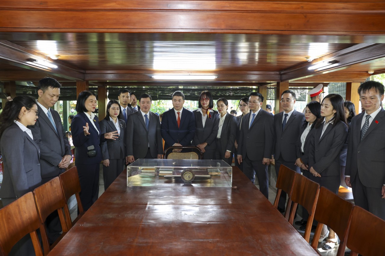 The delegation visits the Ho Chi Minh Relic Site and listens to stories about his life and character. (Photo: Đinh Hòa)