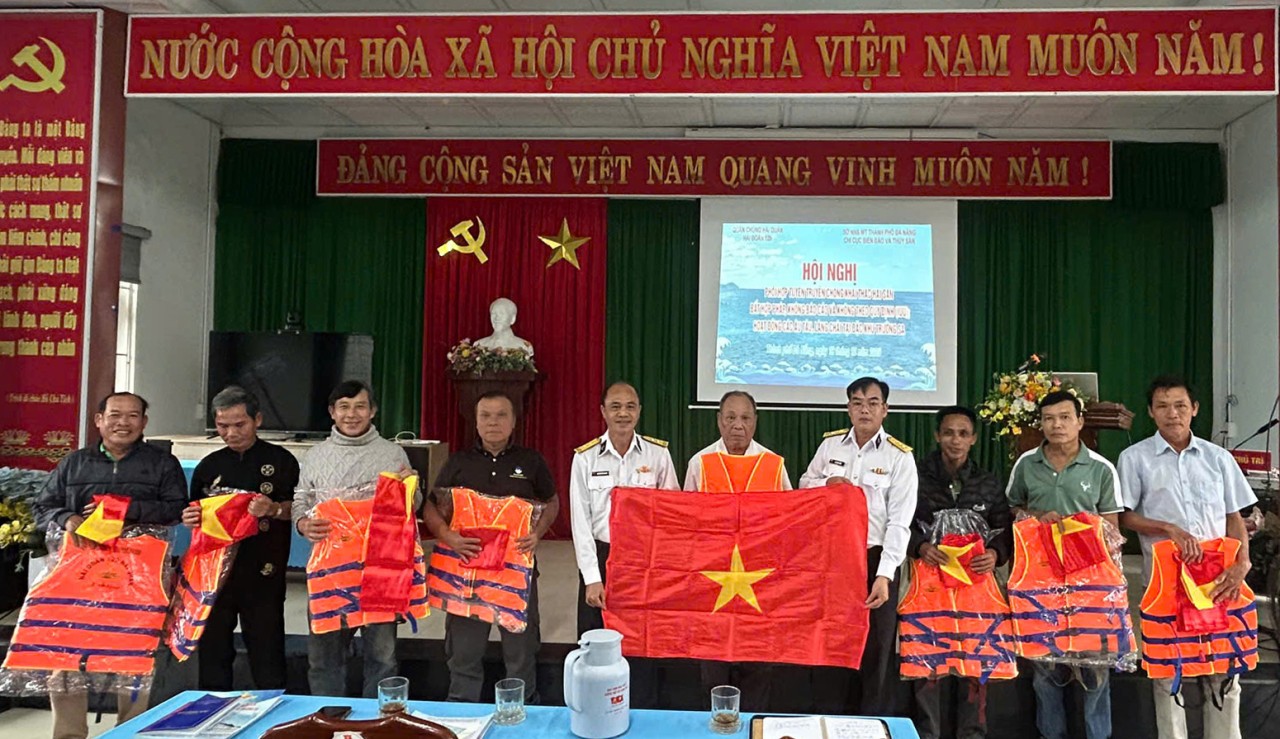 Presenting national flags and personal life jackets to fishermen. (Photo: Duy Tan/Vietnam Naval Newspaper) Presenting national flags and personal life jackets to fishermen. (Photo: Duy Tan/Vietnam Naval Newspaper)