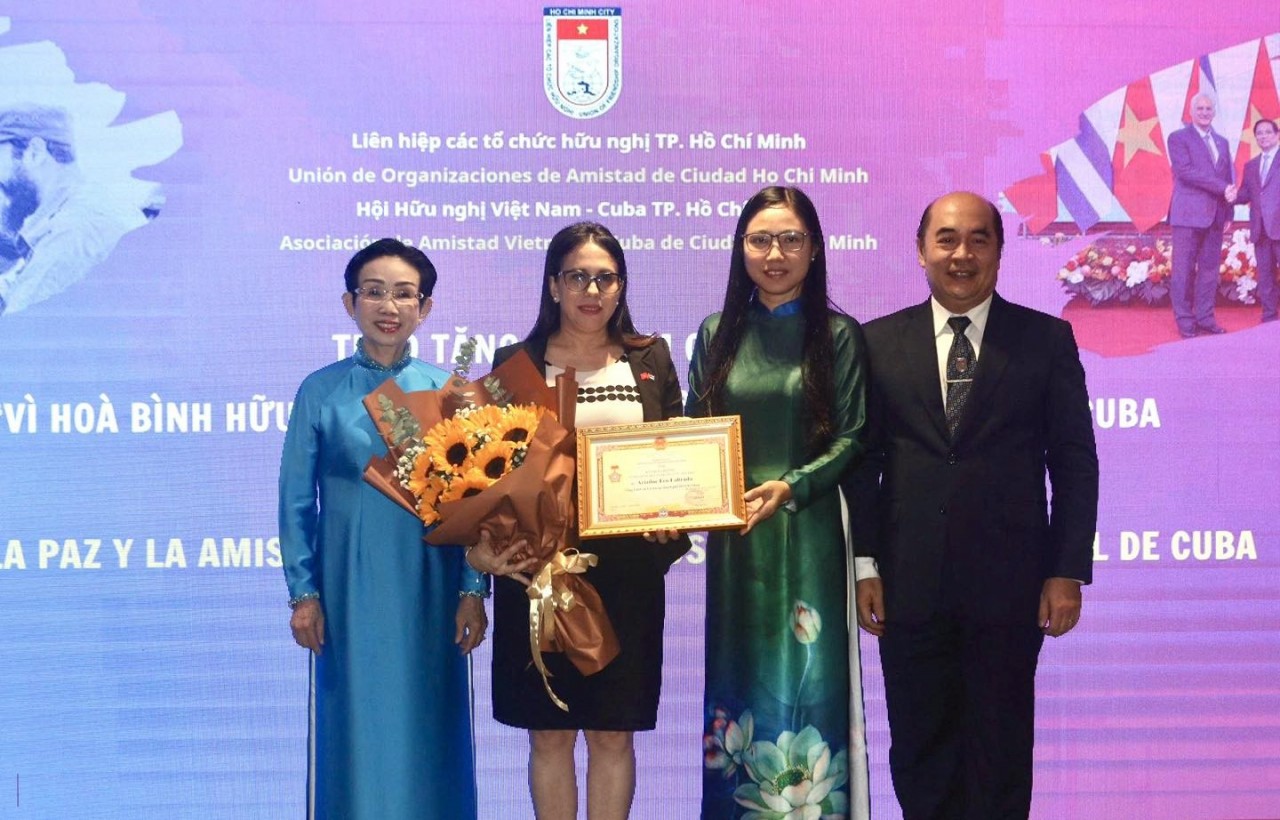 Ha Thanh, President of the Ho Chi Minh City Union of Friendship Organizations (second from the right), presents the medal “For Peace and Friendship Among Nations” of the Vietnam Union of Friendship Organizations to Ariadne Feo Labrada, Consul General of the Republic of Cuba in Ho Chi Minh City (second from the left). (Photo: Ho Chi Minh City Union of Friendship Organizations)