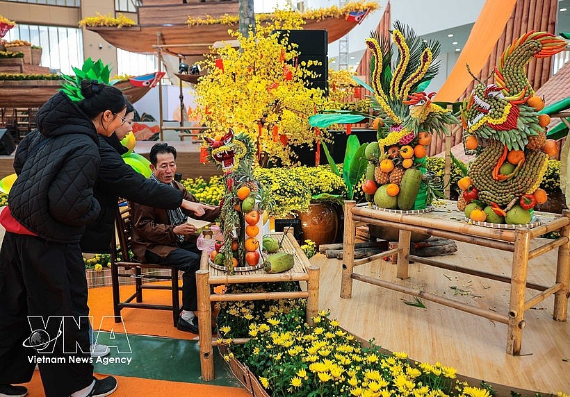 Many visitors explore artistic fruit creations crafted by artisan Nguyen Van Tuyen from Ho Chi Minh City. (Photo: VNA)