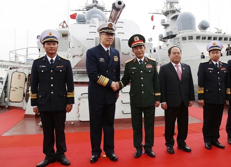 The Defence Ministers of Vietnam and China pose for a photo ahead of the vessels' departure for the joint patrol.