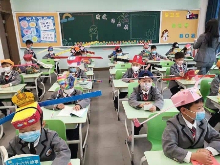 Chinese primary students return schools with self-made ‘distancing hats’