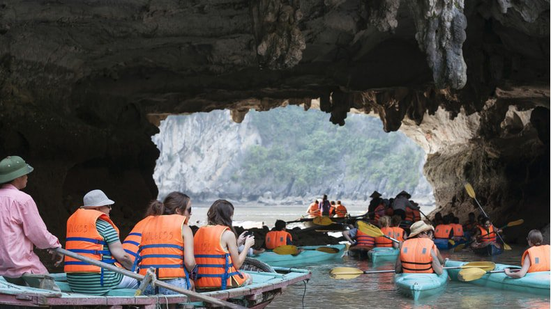 Tourist kayaking through a cave in Halong bay (Photo: Shutterstock) 3656-c14c944065c1c71c01d5ae6cc52a4ca3