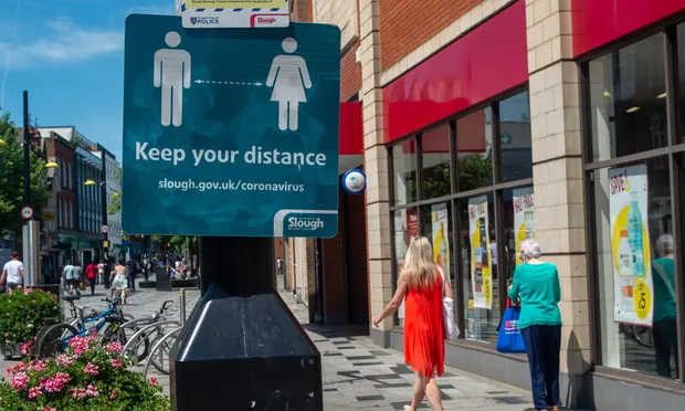 A sign reminding shoppers to stay distanced on Slough High Street. Photograph: Maureen McLean/REX/Shutterstock A sign reminding shoppers to stay distanced on Slough High Street. Photograph: Maureen McLean/REX/Shutterstock