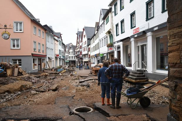 A man and a woman stand with a wheelbarrow as they look at the destroyed pavement of the pedestrian zone in Bad Muenstereifel, western Germany, on July 16, 2021. INA FASSBENDER/AFP VIA GETTY IMAGES A man and a woman stand with a wheelbarrow as they look at the destroyed pavement of the pedestrian zone in Bad Muenstereifel, western Germany, on July 16, 2021. INA FASSBENDER/AFP VIA GETTY IMAGES