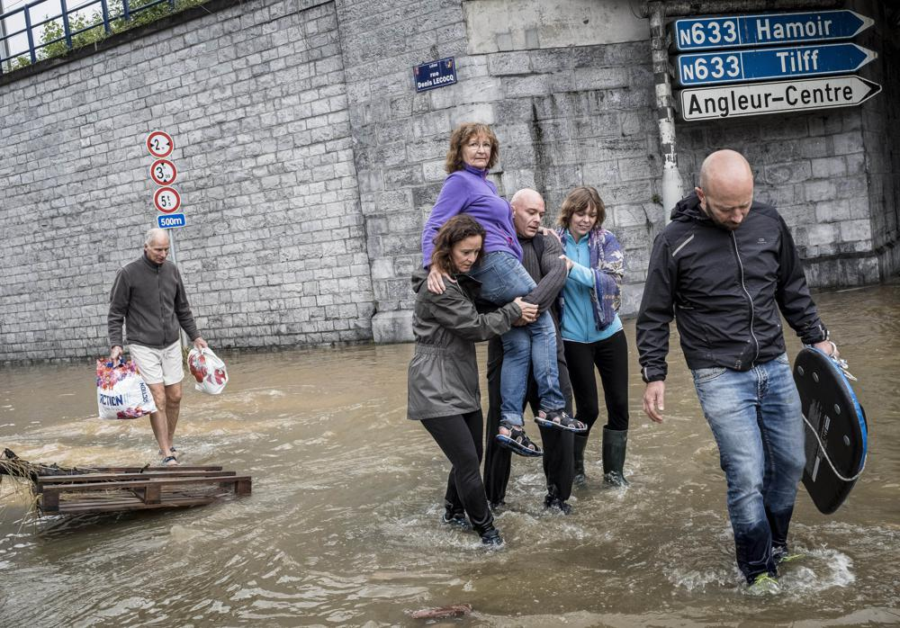 A woman is carried through a flooded street in Angleur, Province of Liege, Belgium, Friday July 16, 2021. Severe flooding in Germany and Belgium has turned streams and streets into raging torrents that have swept away cars and caused houses to collapse. (AP Photo/Valentin Bianchi) A woman is carried through a flooded street in Angleur, Province of Liege, Belgium, Friday July 16, 2021. Severe flooding in Germany and Belgium has turned streams and streets into raging torrents that have swept away cars and caused houses to collapse. (AP Photo/Valentin Bianchi)