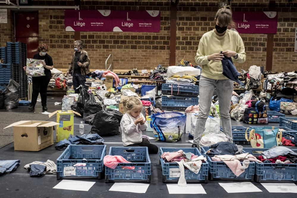 A woman sorts through clothing in a shelter for residents after flooding in Angleur, Province of Liege, Belgium, Friday July 16, 2021. Photo: AP A woman sorts through clothing in a shelter for residents after flooding in Angleur, Province of Liege, Belgium, Friday July 16, 2021. Photo: AP