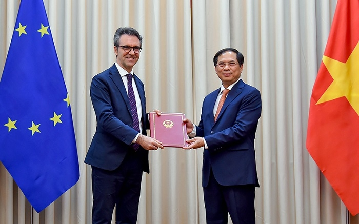 Permanent Deputy Minister of Foreign Affairs Bui Thanh Son (R) hands over a diplomatic note notifying the Vietnamese National Assembly's ratification of the EVFTA and EVIPA to Ambassador of the EU to Vietnam Giorgio Aliberti on June 18 in Hanoi. (Photo: Ministry of Foreign Affairs) 0005-signing