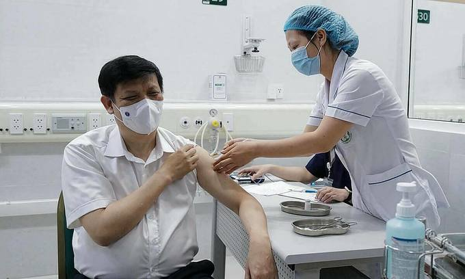 Minister of Health Nguyen Thanh Long receives a Covid-19 vaccine shot by AstraZeneca at Hanoi's Bach Mai Hospital, May 6, 2021. Photo by VnExpress/Ngoc Thanh. Minister of Health Nguyen Thanh Long receives a Covid-19 vaccine shot by AstraZeneca at Hanoi's Bach Mai Hospital, May 6, 2021. Photo by VnExpress/Ngoc Thanh.