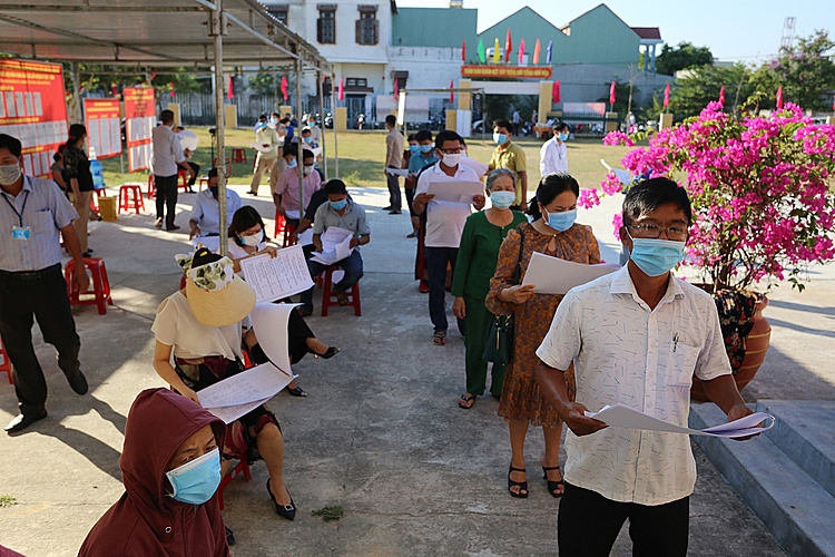 People read off the list of candidates prior to voting in Quang Nam. Huynh Thi Tuyet, 75, said it's already the 11th time she's voted, adding that she chooses Voting begins in 80,000 polling stations nationwide