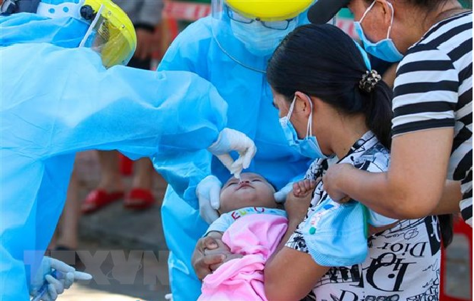 A medical worker is taking sample of a baby for COVID-19 testing. (Photo: VNA) 5440 baby testing