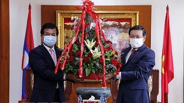 Deputy head of the Lao People’s Revolutionary Party Central Committee’s Commission for External Relations Somphone Sichaleun (L) presents flowers to Deputy Foreign Minister Phoxay Khaykhamphithoune (Photo: VNA) Deputy head of the Lao People’s Revolutionary Party Central Committee’s Commission for External Relations Somphone Sichaleun (L) presents flowers to Deputy Foreign Minister Phoxay Khaykhamphithoune (Photo: VNA)