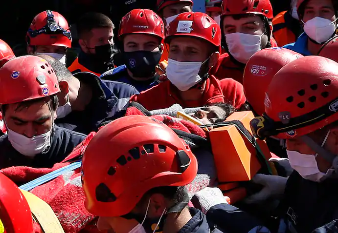 Medics and rescue personnel carry an injured person from the debris of a collapsed building in Izmir. (Emrah Gurel/AP) 1915 turkey 3