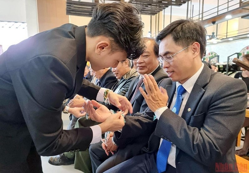Lao students perform a wrist-tying ceremony for attendees. (Photo: Nhan Dan Newspaper) Lao students perform a wrist-tying ceremony for attendees. (Photo: Nhan Dan Newspaper)