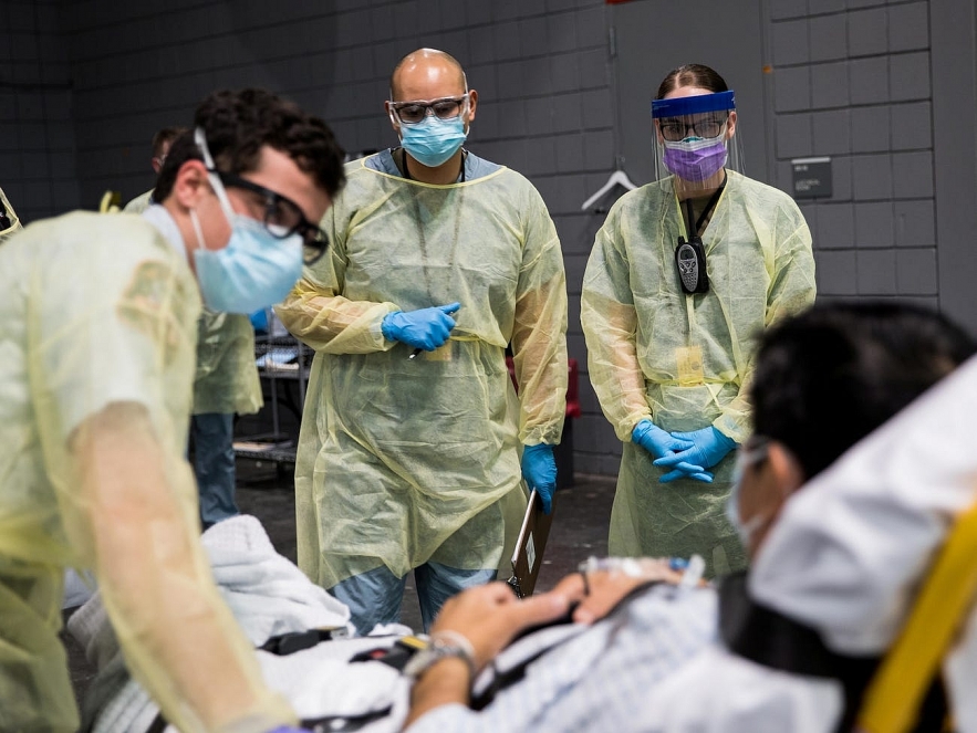 Soldiers assigned to the Javits New York Medical Station conduct check-in procedures on an incoming coronavirus patient with local emergency workers in New York City, April 5, 2020. Photo: U.S. Navy 5335 covid usa 1