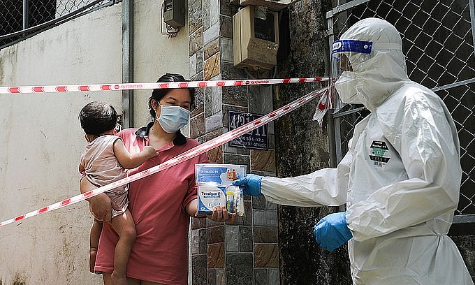 A medic hands a package of medicine for Covid-19 patient to a HCMC resident, September 3, 2021. Photo: VnExpress A medic hands a package of medicine for Covid-19 patient to a HCMC resident, September 3, 2021. Photo: VnExpress