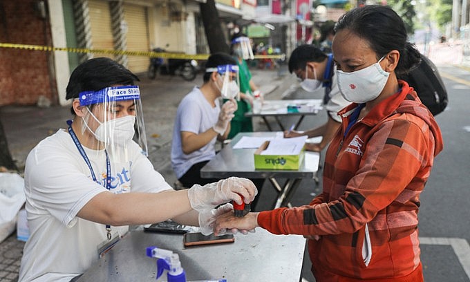 A medical staff stamps ink on the hand of a woman at a shopping location in District 5, Ho Chi Minh City, September 22, 2021. Photo: VnExpress A medical staff stamps ink on the hand of a woman at a shopping location in District 5, Ho Chi Minh City, September 22, 2021. Photo: VnExpress