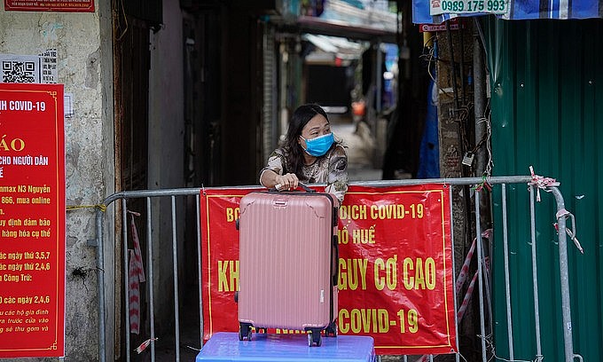 A woman in an isolated area on Nguyen Cong Tru Street in Hanoi's Hai Ba Trung District receives goods delivered to her by relatives, December 1, 2021. Photo: VnExpress A woman in an isolated area on Nguyen Cong Tru Street in Hanoi's Hai Ba Trung District receives goods delivered to her by relatives, December 1, 2021. Photo: VnExpress