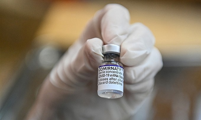 A medical staff holds a bottle of Covid-19 vaccine in Hanoi, November 2021. Photo: VnExpress A medical staff holds a bottle of Covid-19 vaccine in Hanoi, November 2021. Photo: VnExpress